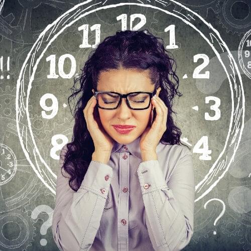 Women frustrated holding her head with a clock behind her